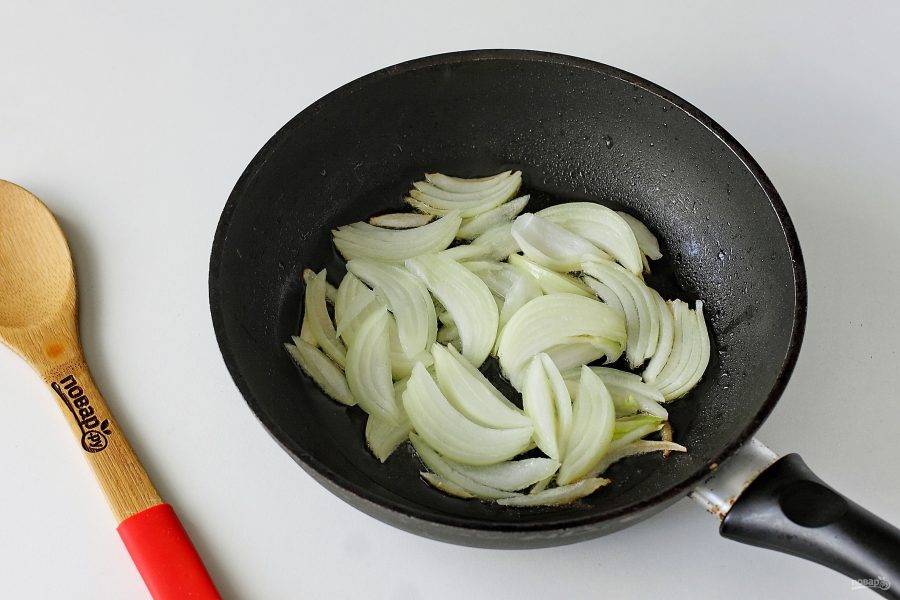 Сковороду разогрейте, налейте растительное масло и выложите лук, нарезанный перьями или полукольцами.