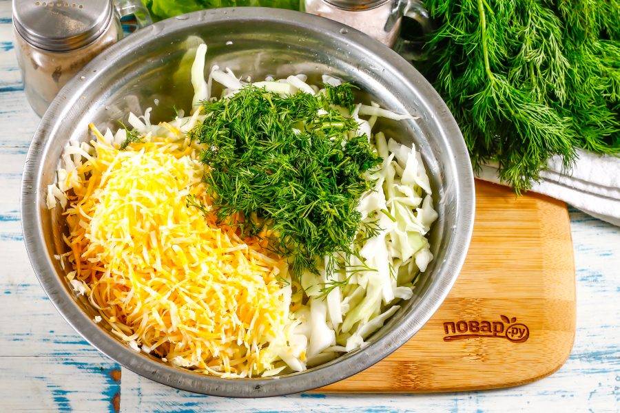 Натрите в емкость к капустной нарезке твердый сыр выбранного вами сорта. Промойте зелень укропа и измельчите, всыпьте туда же и добавьте щепотку молотого черного перца.