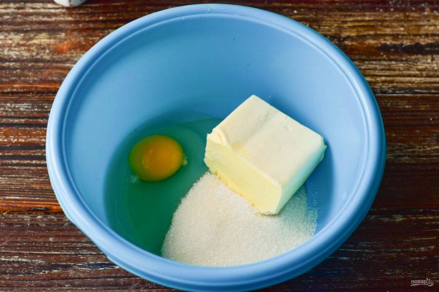В миску вбейте яйцо, выложите сливочное масло. Всыпьте соль и сахар.