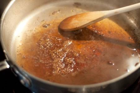 6. Пока запекается мясо можно заняться соусом для подачи блюда на стол. На сковороду, в которой жарилось мясо, добавить немного бульона (можно использовать обычную воду). Довести до кипения, помешивая. 