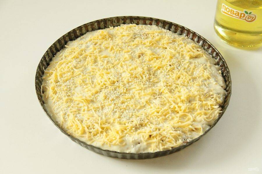 11. Сверху ложкой разровняйте вторую половину теста. Посыпьте верх тертым сыром и кунжутом по желанию. Выпекайте пирог при 180 градусах около 30 минут.
