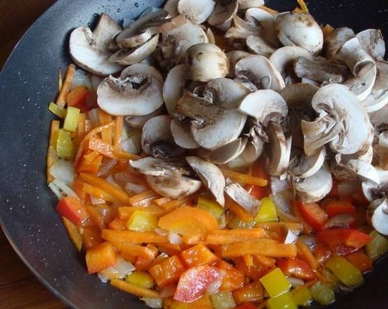 Тушим лук, морковку, перец и грибы.