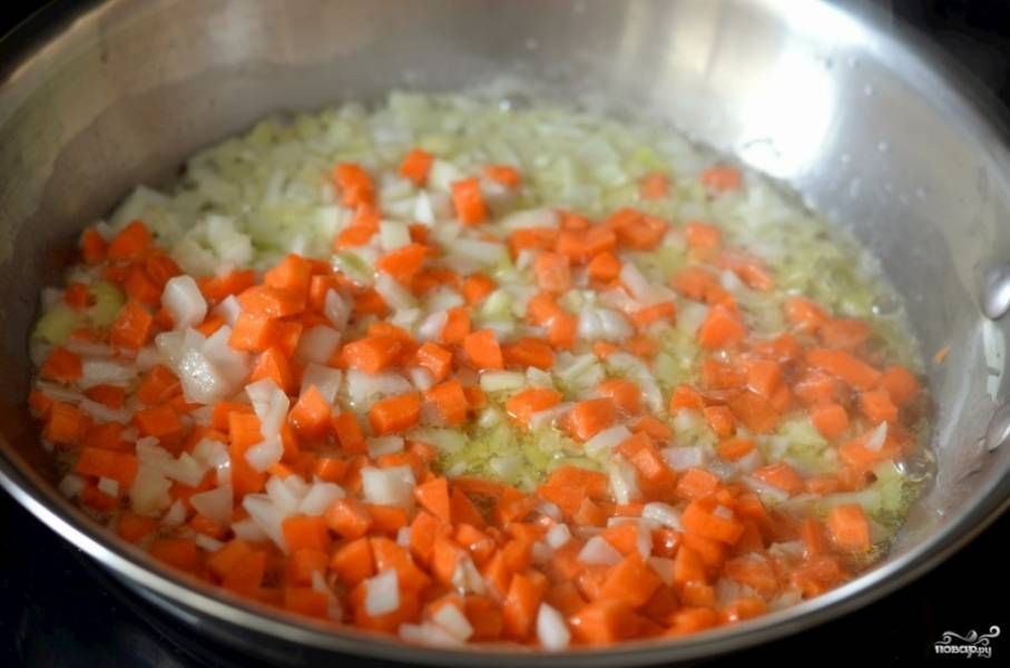 1. Первым делом поставьте вариться рис в подсоленной воде. Овощи очистите и нарежьте небольшими кусочками. На сковороду выложите сливочное и оливковое масло, разогрейте, отправьте туда лук с морковью. Обжарьте 3-4 минуты, постоянно помешивая. 