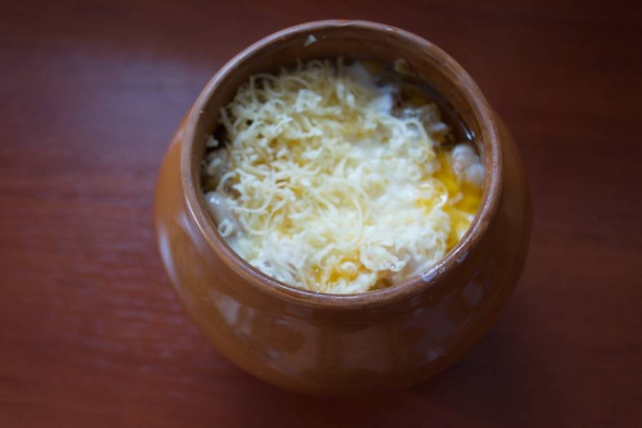 Разогрейте духовку до 200 градусов. Натрите на терке твердый сыр. Посыпьте сверху жаркое сыром. Закройте горшочек крышкой и запекайте в духовке около 1 часа.