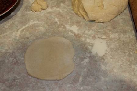 7. Когда тесто подошло, а начинка как следует остыла можно начинать лепить пирожки. Небольшой кусочек теста раскатать на поверхности в тоненькую лепешку. 