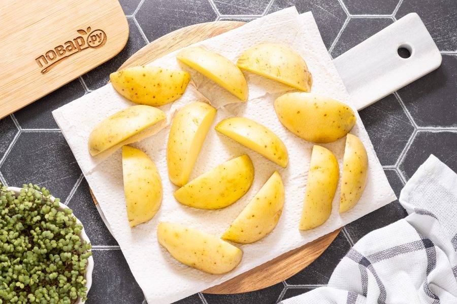С помощью бумажных салфеток обсушите дольки, так картофель получится более хрустящим при запекании.
