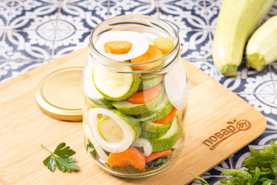 Заполните банку кабачками с морковью и репчатым луком чередуя слои.