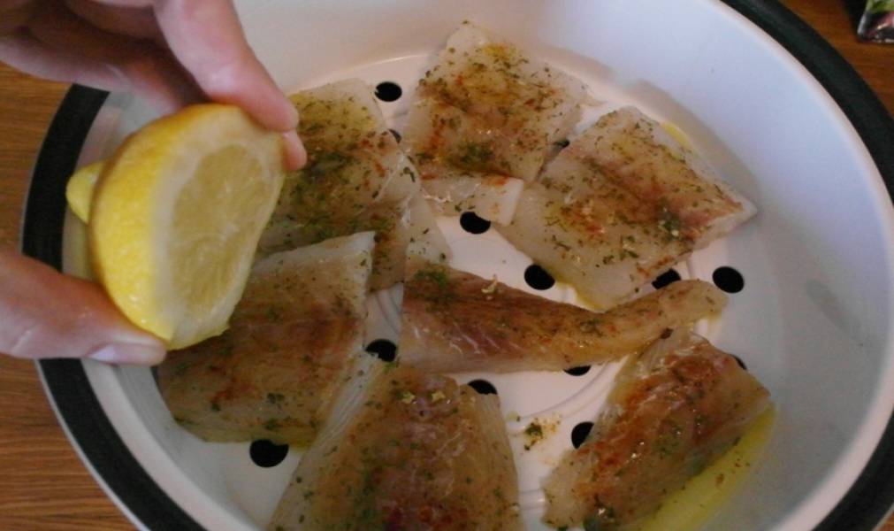 Выкладываем рыбу в пароварку, сбрызгиваем оливковым маслом и лимонным соком.