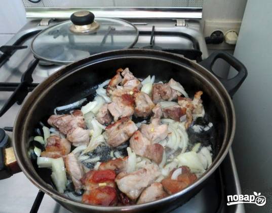 Отправьте мясо жариться на сковороду с растительным маслом. Тем временем лук порежьте полукольцами и отправьте его тоже в сковороду.