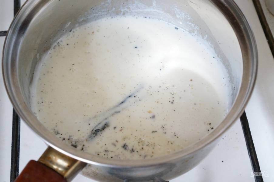 Приготовьте заварной крем. Молоко с ванилью доведите до кипения.