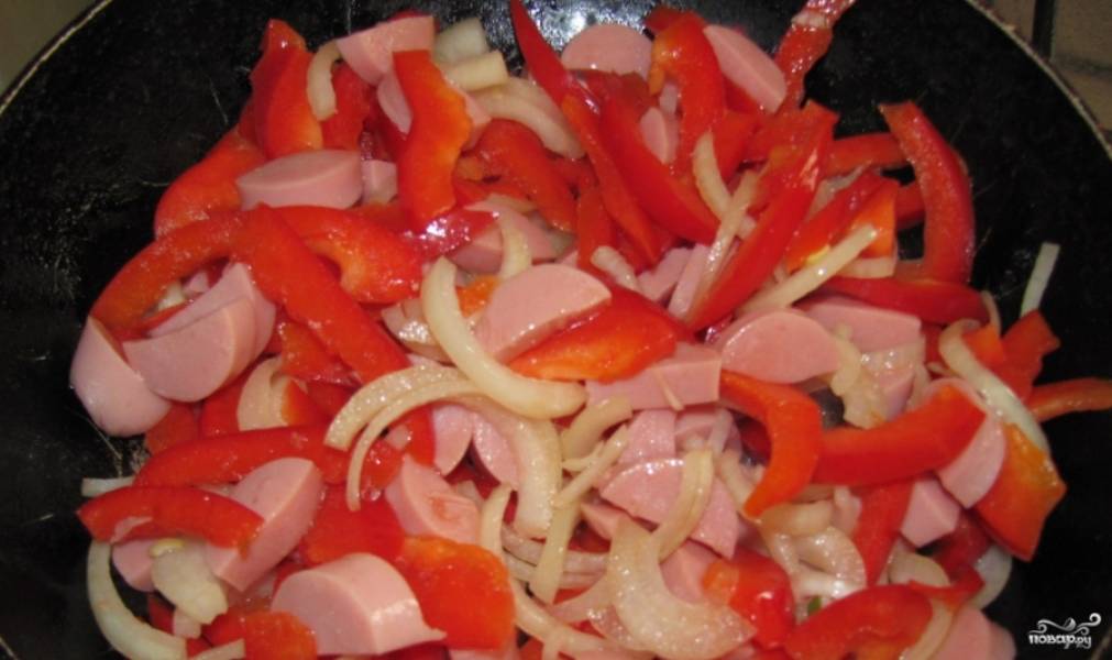 3. Пока бульон с картошкой готовится, обжарим на сковороде сосиски вместе с луком и перцем, а затем добавим нашу томатную смесь, перемешаем, доведём до кипения и на маленьком огне протушим еще 5 минут, после чего возвращаем к бульону. Варим все вместе еще 10 минут.