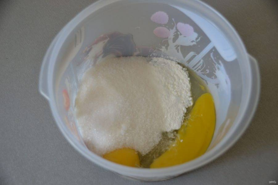В емкость для взбивания положите 2 яичных желтка, всыпьте сахар и крахмал.
