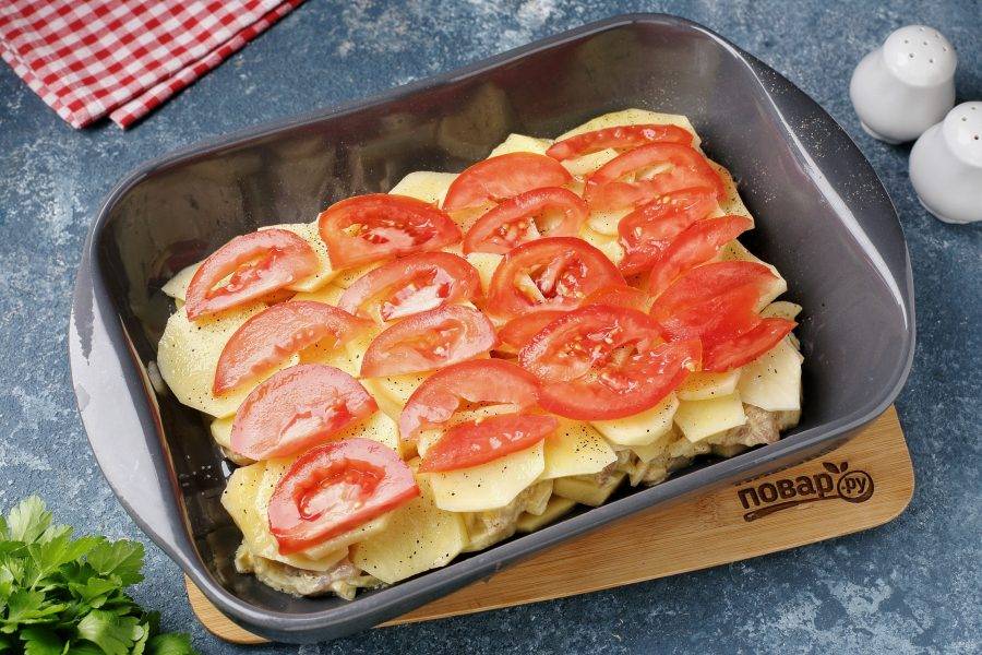 На картофель выложите нарезанные дольками помидоры.