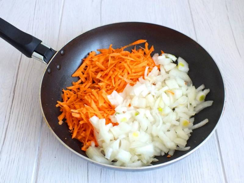 Репчатый лук нарежьте произвольно, морковь натрите на крупной терке. Обжарьте овощи на растительном масле до готовности.