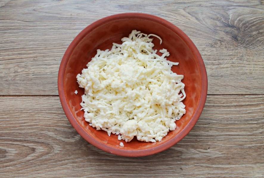 Сыр сулугуни натрите на средней терке или разомните вилкой.