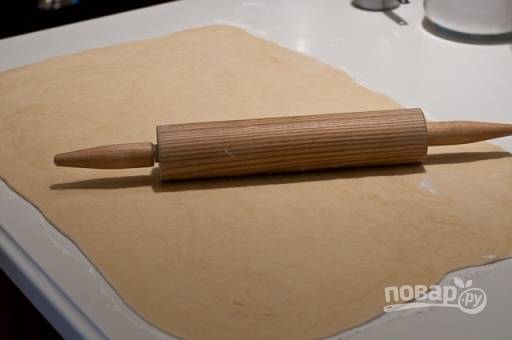 Готовое тесто раскатываем на большой поверхности, посыпанной мукой, в тонкий пласт.