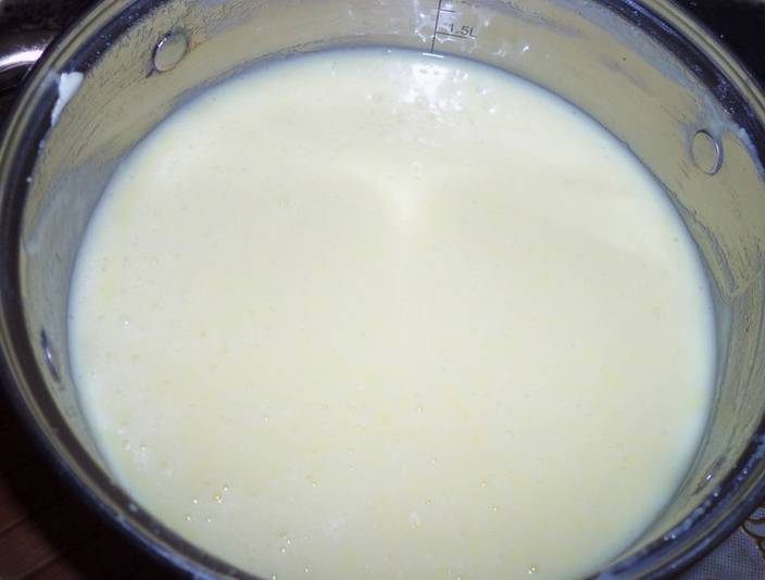 Когда молочная масса остынет, добавьте туда мягкое сливочное масло и взбейте всё блендером. Должен получиться однородный гладкий крем. По желанию можете поставить его в холодильник на 10-15 минут, чтобы он немного загустел перед формированием торта. 