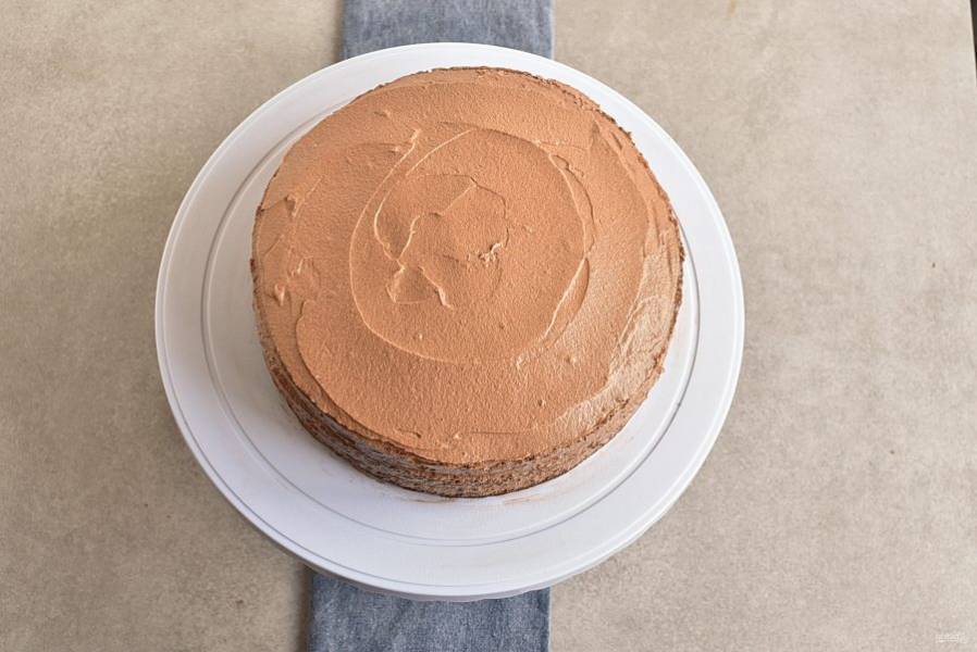 Смажьте коржи толстым слоем крема. Покройте торт кремом и сверху. Уберите в морозилку минут на 15.
