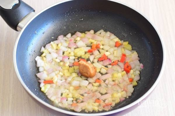 На прогретой  сковороде  обжарьте овощи на среднем огне до мягкости, 6-7 минут. Добавьте в сковороду кубик рыбного бульона.