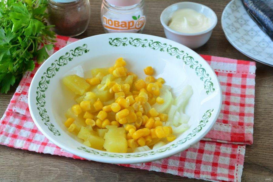 В салатник выложите нарезанный картофель, лук и кукурузу.