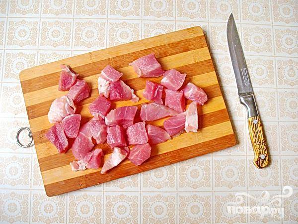 2.	Нарезаем небольшими кусочками свинину, (использовать можно и мясо курицы), промываем его, обсушиваем, немного перчим и солим.  Укладываем его в горшочки, сверху на парж.