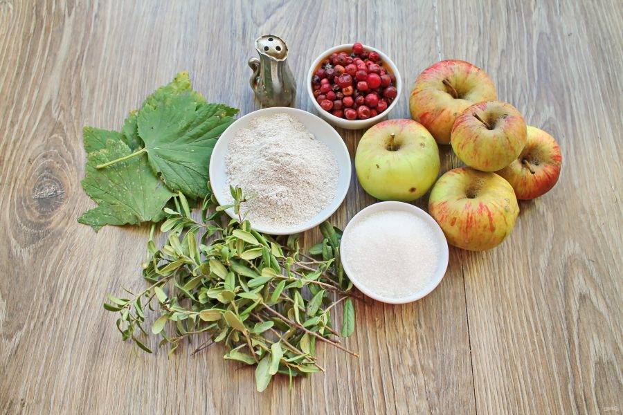 Подготовьте все необходимые ингредиенты для приготовления моченых яблок с брусникой. Ягоды переберите, удаляя мятые и испорченные. Яблоки, листья и ягоды вымойте в горячей воде.  