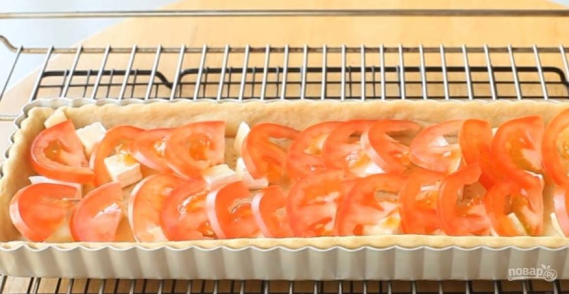 3. Отправьте основу в разогретую до 190 градусов духовку на 15 минут. Затем выньте наполнитель и оставьте еще на 5 минут при 180 градусах. Сыр, оливки и помидоры нарежьте небольшими кусочками. 