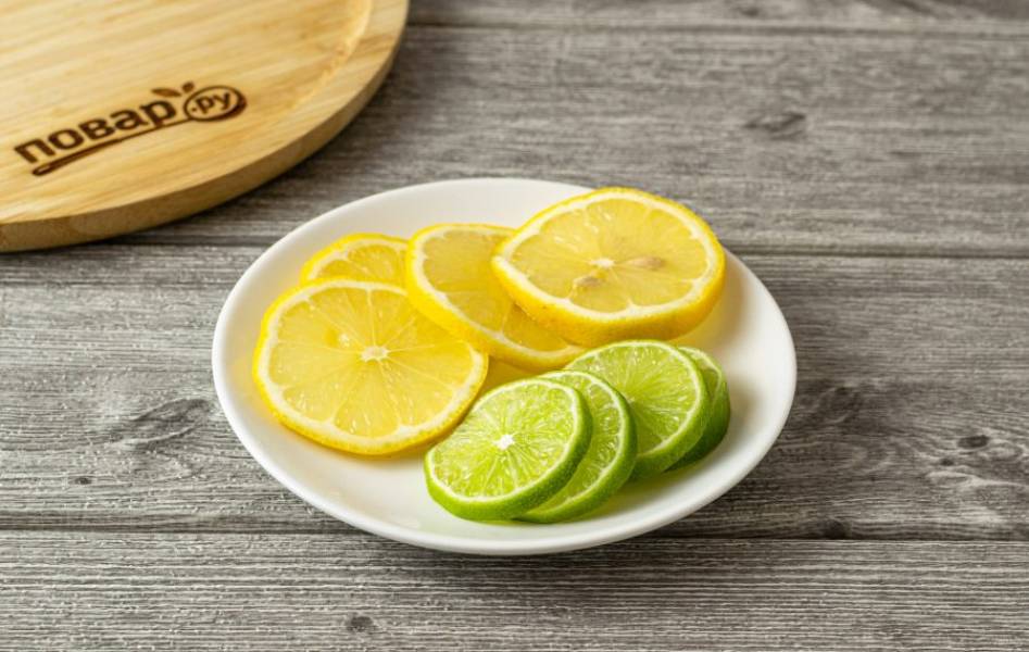 Лимон и лайм тщательно помойте. Нарежьте на тонкие кружочки.