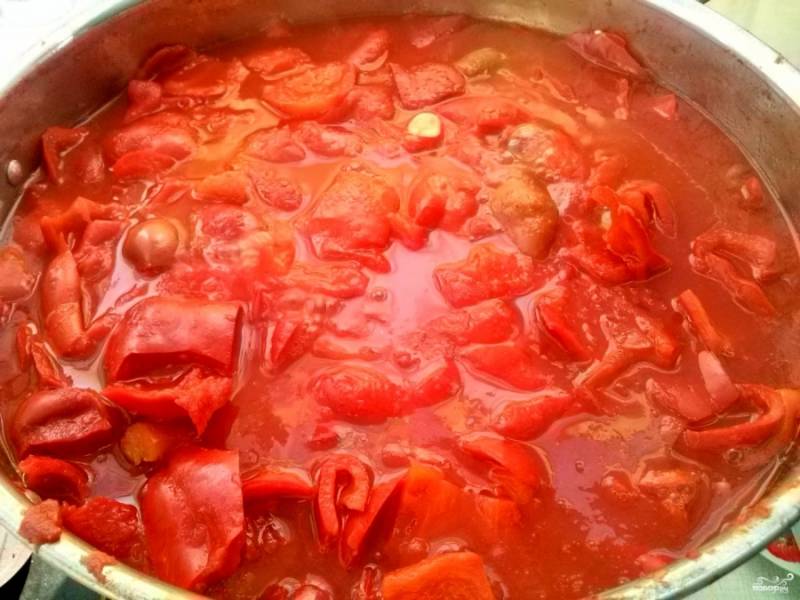 Пока томат закипает, нарежьте перец ломтиками, которые вам будет удобно накалывать на вилку. Переложите перец в томат, дайте закипеть, а потом проварите 30 минут. Чеснок нарежьте мелкими ломтиками и добавьте в конце варки. 