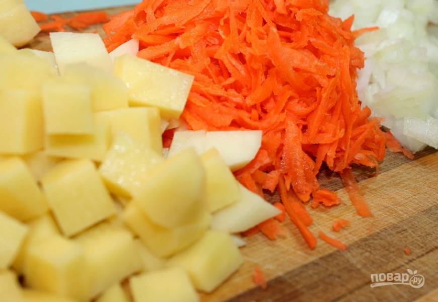 Овощи промываем и очищаем. Картофель нарезаем кубиками, морковь трем на терке, а лук измельчаем любым удобным для вас образом.