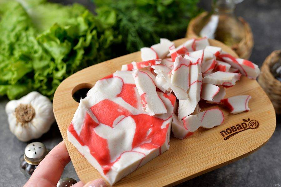Нарежьте крабовое мясо тонкими слайсами. 