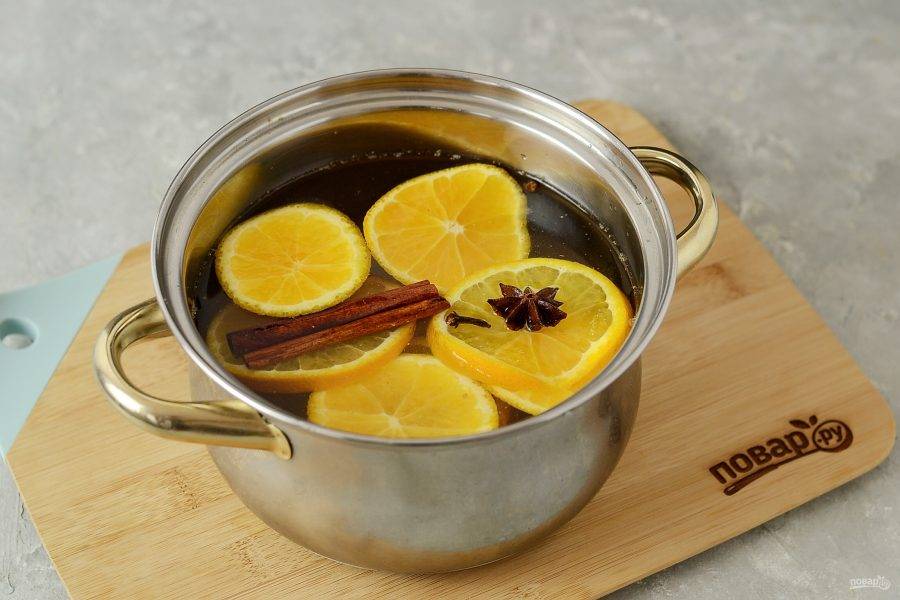 В отдельной кастрюле соедините нарезанный кружочками апельсин, корицу, бадьян и имбирь. Залейте оставшейся водой и варите 10 минут. В конце добавьте мед. 
