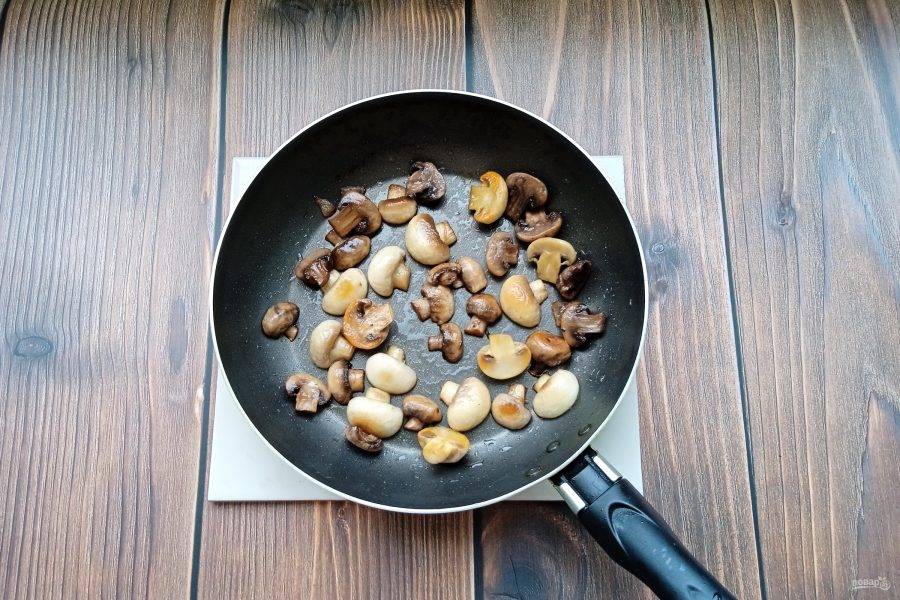 Пока картофель варится, шампиньоны промойте, порежьте на две части и выложите в сковороду с подсолнечным маслом. Жарьте до золотистого цвета. Посолите, поперчите.