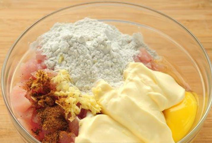 Смешайте в миске куриное филе, майонез, крахмал, яйцо, чеснок, соль, специи и хорошо перемешайте.