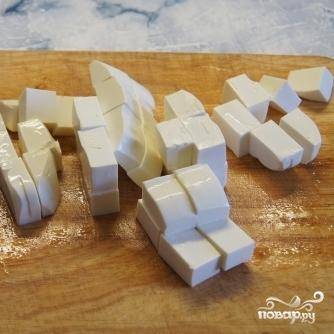 Сыр также нарезать на небольшие кусочки.