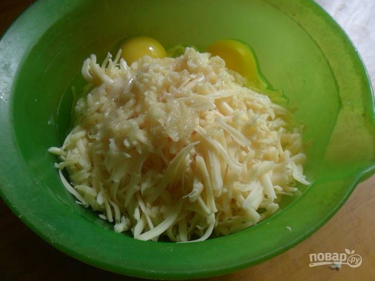 4.	В миску выложите сыр, чеснок, добавьте к ним куриные яйца, перемешайте.