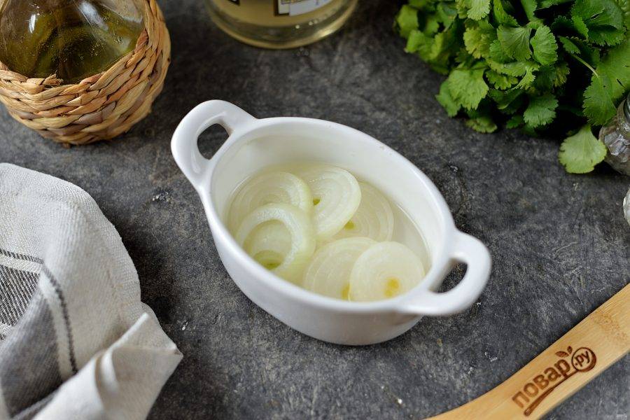 Нарежьте лук тонкими кружочками, выложите в небольшую емкость, залейте столовой ложкой уксуса, добавьте немного воды, оставьте на время, лук должен замариноваться, чтобы не быть горьким в салате.