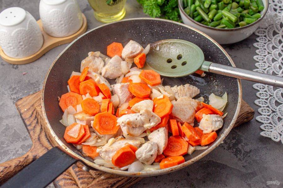 Морковь нарежьте тонкими кружочками и отправьте в сковороду, жарьте до мягкости овощей.
