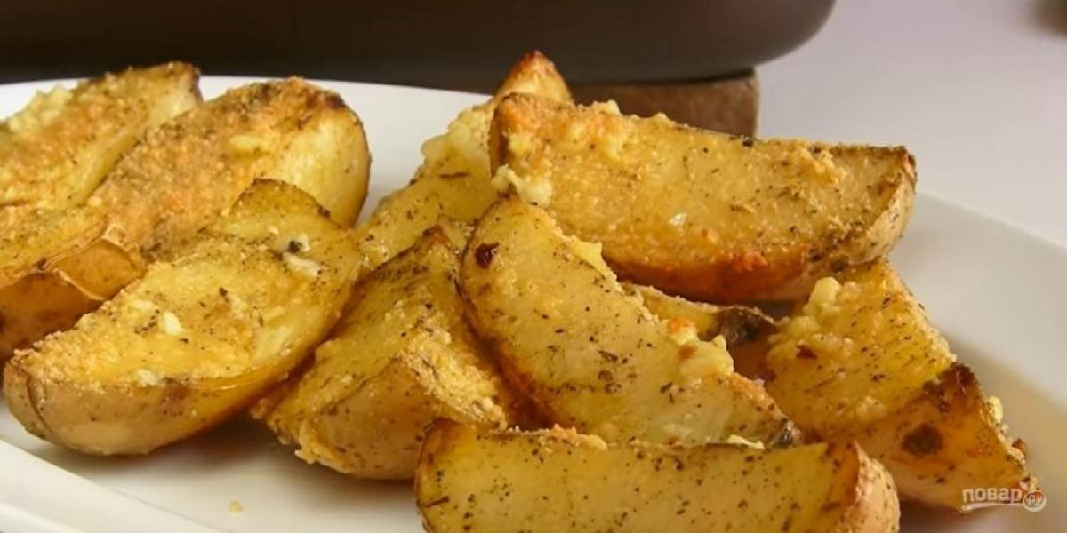 4. Полейте картофель растопленным маслом с чесноком, посыпьте тертым пармезаном и отправьте допекаться до готовности. Приятного аппетита!