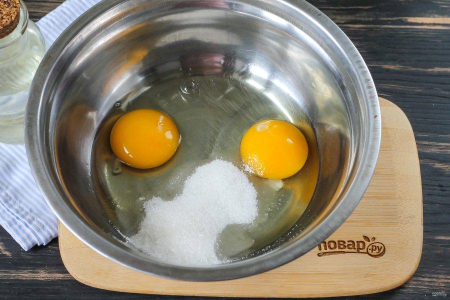 В глубокую емкость вбейте куриные яйца, всыпьте соль и сахар, тщательно все взбейте.