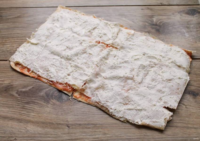 Выложите сверху второй лаваш и смажьте сливочным сыром ровным слоем.
