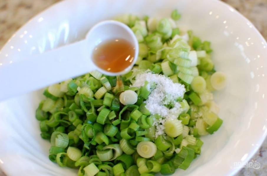 3.	Промойте зеленый лук, порежьте его, посолите и добавьте 1 столовую ложку кунжутного масла, перемешайте и отложите.