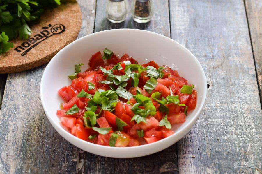 Переложите помидоры в миску, добавьте нарезанный мелко базилик.