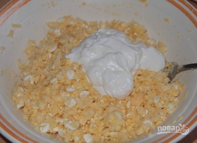 Измельчите яйца вместе с твёрдым сыром и чесноком в миске. Добавьте к ним творожный сыр и майонез. Перемешайте массу.