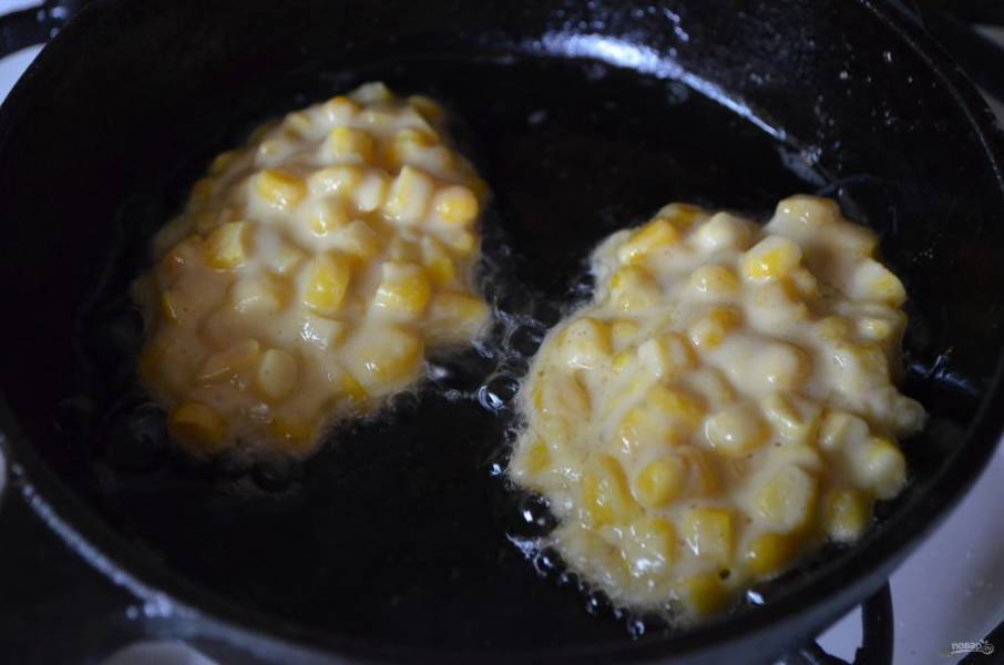 8. В сковороде разогрейте до кипения растительное масло, столовой ложкой набирайте кукурузную массу и выкладывайте её в жир. Жарьте по несколько минут с каждой стороны.