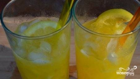 Апельсин и лимон нарежьте некрупными дольками. Добавьте в стаканы по 2 столовых ложки льда и сразу разложите дольки цитрусовых.