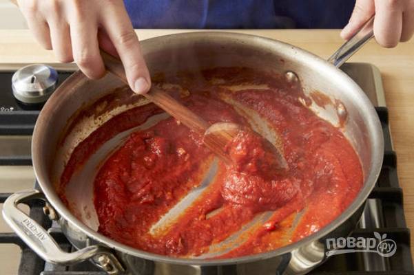 В сковороду влейте 2 ч. ложки масла, обжарьте минуту порубленный чеснок, затем влейте томатную пасту, обжарьте минутку, влейте томатный соус и положите измельченные оливки. Добавьте соль и перец, тушите 5 минут.