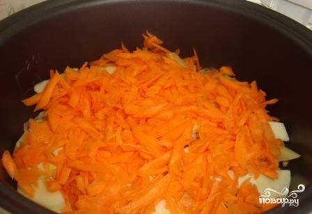 Очищенную морковь натираем на крупной терке и выкладываем поверх кабачка.