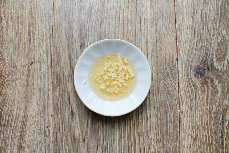 Смешайте лимонный сок, мед, соль и растительное масло до однородной массы. Чеснок очистите и измельчите, добавьте в смесь и перемешайте.