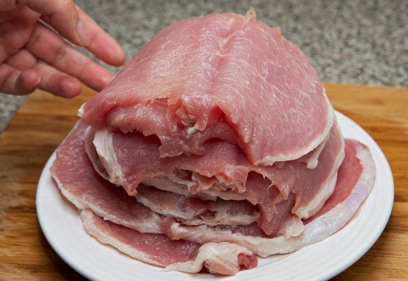 7. Рецепт приготовления рулетиков из свинины в духовке далее переходит ко второму этапу - нарезке мяса. Свинину нужно вымыть, просушить и нарезать острым ножом на отбивные. Слегка отбить каждый кусочек. 